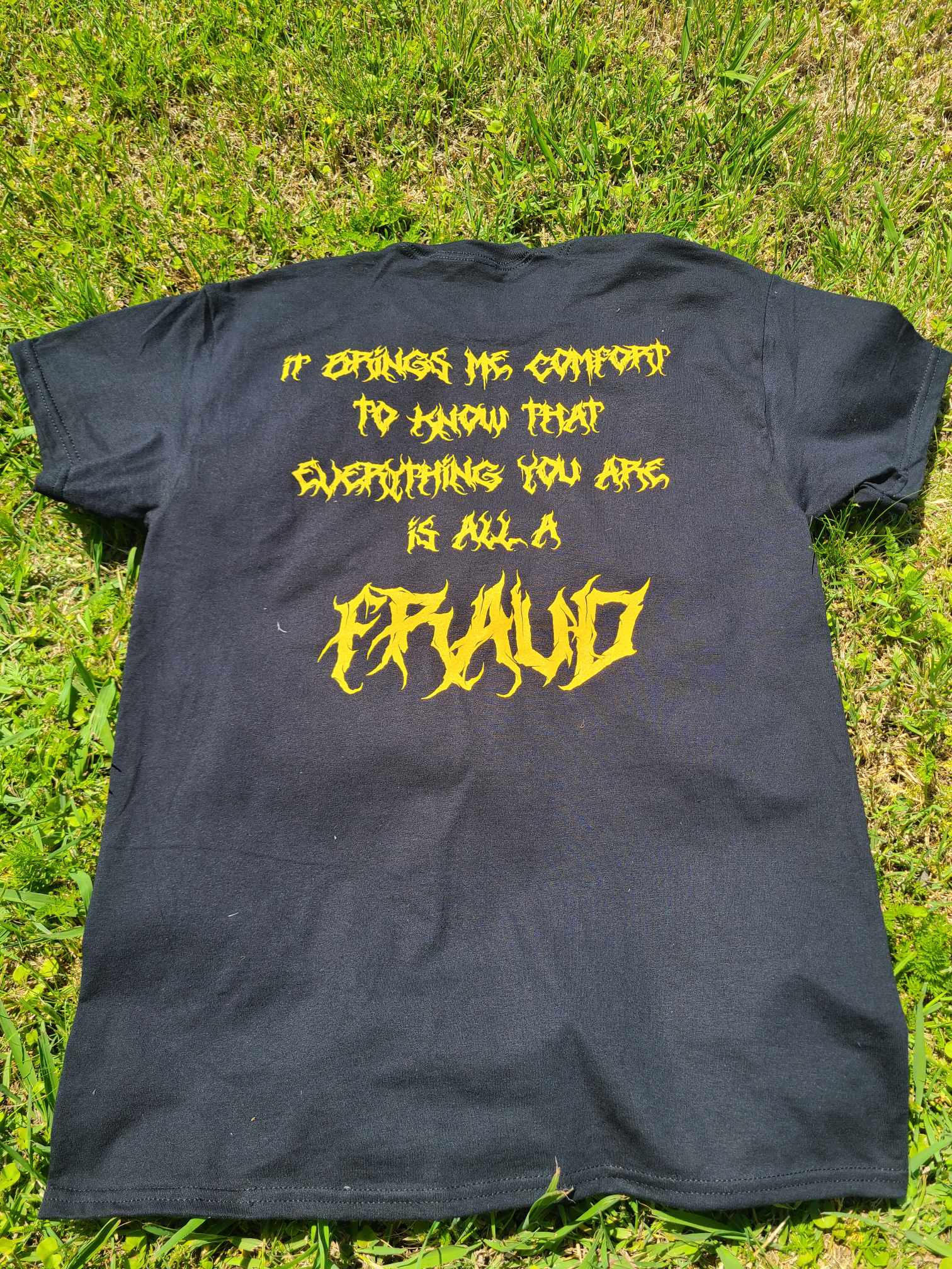 T-Shirt with the lyrics of Fraud on the back of the shirt in the same yellow as the front.